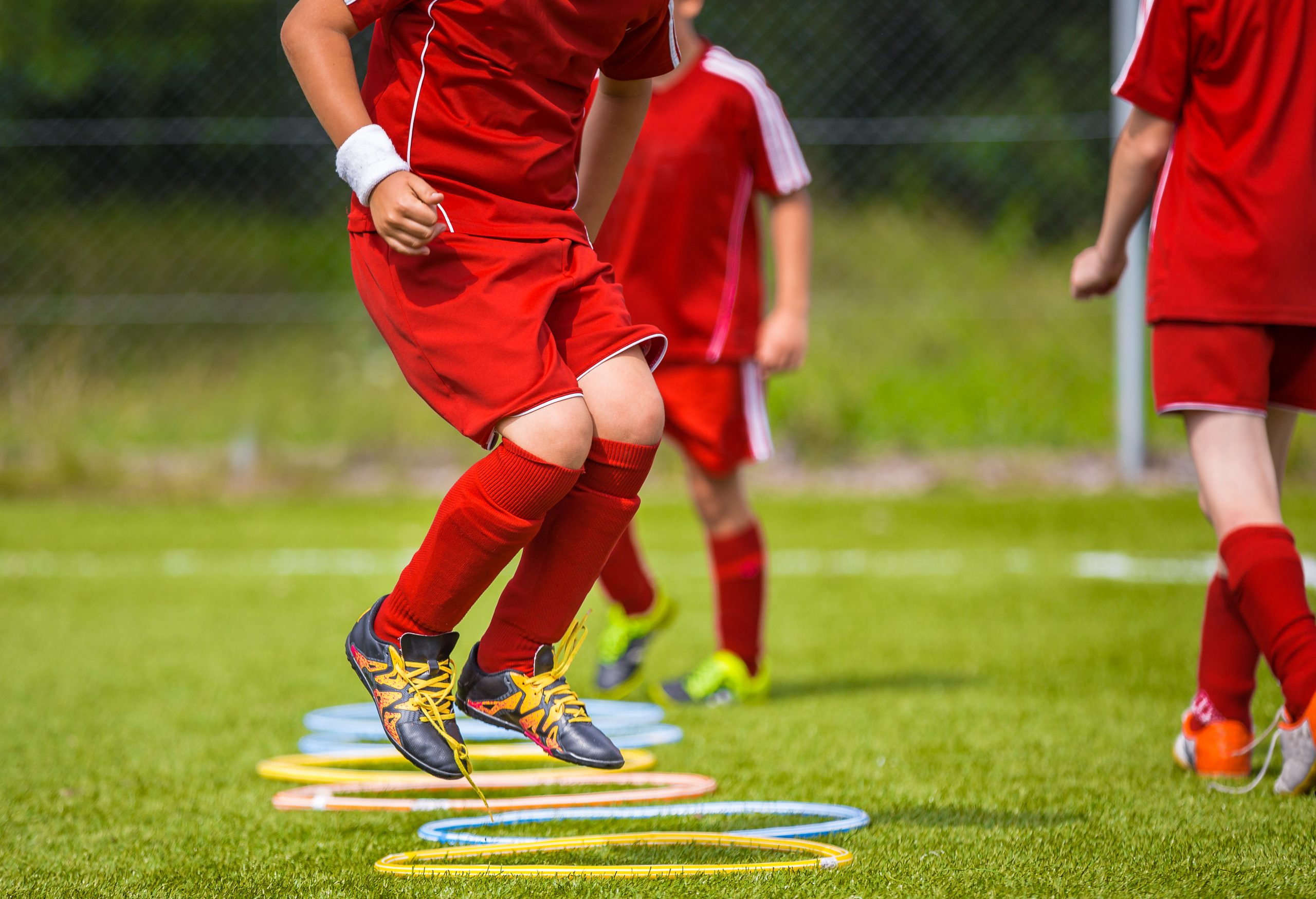 Young Soccer Player Practicing on the Pitch. Soccer Football Equpment. Dynamic Jumping Football Training